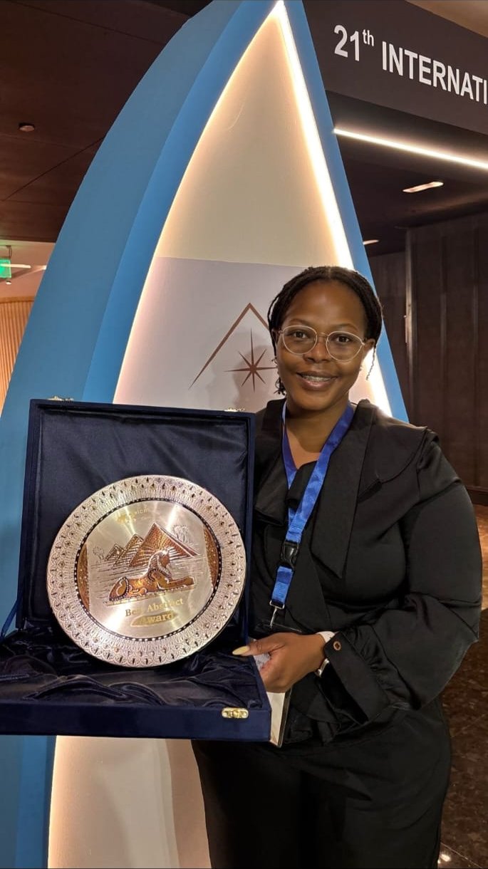 Yonwaba Mzizi holding the Best Abstract Award plaque at the 21st ICRT in Cairo